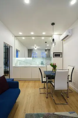 a living room with a table and a blue couch at Moder Chic Apartment in Center-PRIME RENTALS in Kaunas