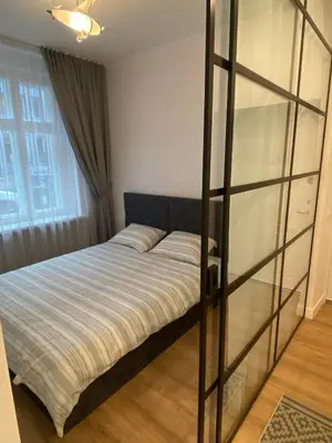a bedroom with a bed and a glass partition at Moder Chic Apartment in Center-PRIME RENTALS in Kaunas