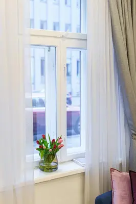 a window with a vase of flowers on a window sill at Moder Chic Apartment in Center-PRIME RENTALS in Kaunas