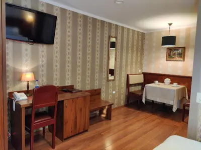 a room with a table and a tv on the wall at Motelis SMAKŲ SMAKAS in Šiauliai