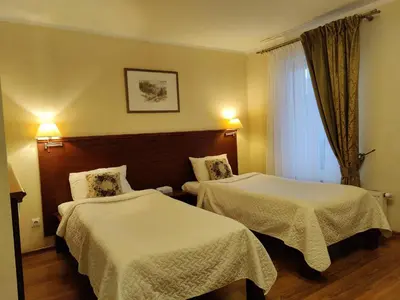 a hotel room with two beds and a window at Motelis SMAKŲ SMAKAS in Šiauliai