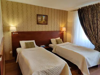 a hotel room with two beds and a window at Motelis SMAKŲ SMAKAS in Šiauliai