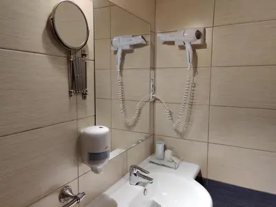 a bathroom with a sink and a mirror and a phone at Motelis SMAKŲ SMAKAS in Šiauliai