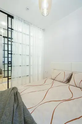 a white bedroom with a large bed with a large window at Modern Rustic in Center-PRIME RENTALS in Kaunas