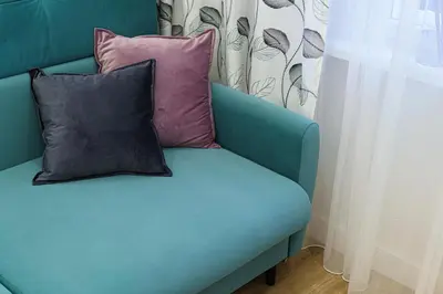 a blue couch with two pillows on it at Modern Scandinavian Feeling-PRIME RENTALS in Kaunas