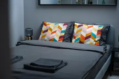 a bed with colorful pillows on it with at E.M. Studio In City Center in Kaunas