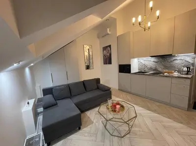 a living room with a couch and a table at E.M. Studio In City Center in Kaunas