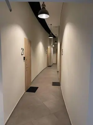 a hallway with a long hallway with doors and a tile floor at E.M. Studio In City Center in Kaunas