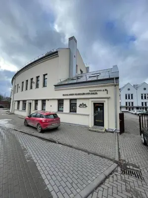 a red car parked in front of a building at E.M. Studio In City Center in Kaunas