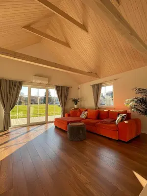 a large living room with a red couch and wooden floors at Mandarinas in Anykščiai