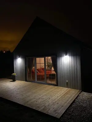 a house with a deck at night with lights at Mandarinas in Anykščiai