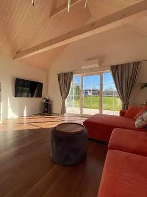a living room with a red couch and a large window at Mandarinas in Anykščiai