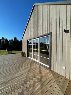 a building with a large window on a deck at Mandarinas in Anykščiai