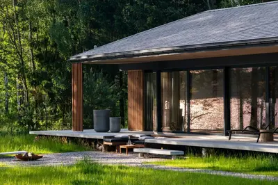 a pavilion with benches and tables in the grass at Villa The Lake in Mindūnai