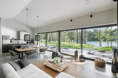 a living room with a white couch and a table at Villa The Lake in Mindūnai