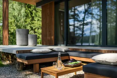 a porch with pillows and a table on a house at Villa The Lake in Mindūnai