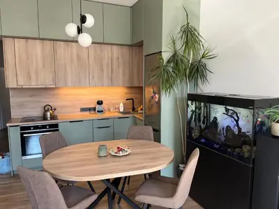 a kitchen with a table and chairs and a fish tank at Happy Kaunas in Kaunas
