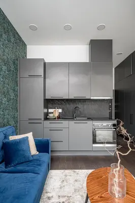 a living room with a blue couch and a kitchen at Vilnius Old-Town Renaissance Studios in Vilnius