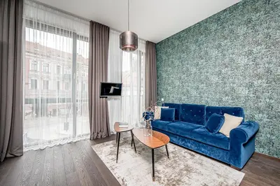a living room with a blue couch and a table at Vilnius Old-Town Renaissance Studios in Vilnius