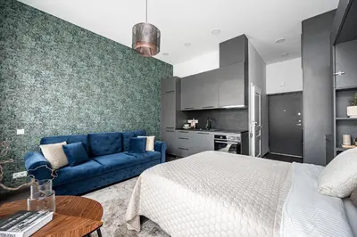 a bedroom with a bed and a blue couch at Vilnius Old-Town Renaissance Studios in Vilnius