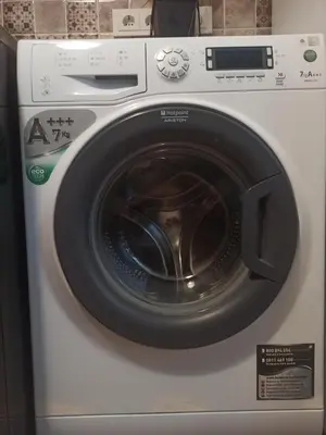 a white washing machine with a black door at Lake apartment in Visaginas