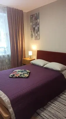 a bedroom with a bed with a purple blanket at Lake apartment in Visaginas