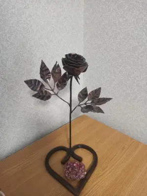 a heart shaped vase with a rose and a donut at Lake apartment in Visaginas