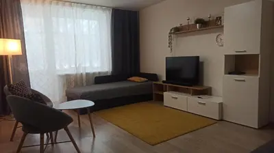a small living room with a couch and a television at Lake apartment in Visaginas