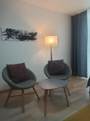two chairs and a table in a room with a lamp at Lake apartment in Visaginas