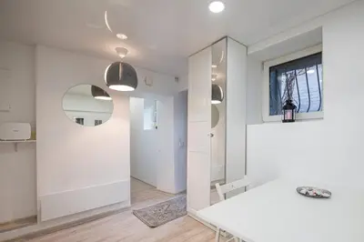 a white room with a table and a mirror at Kepezinski Centre Apartments in Kaunas