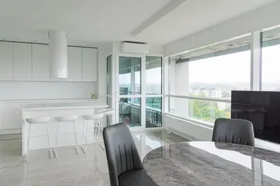 a white kitchen with a table and chairs and windows at VilniausPanorama in Vilnius