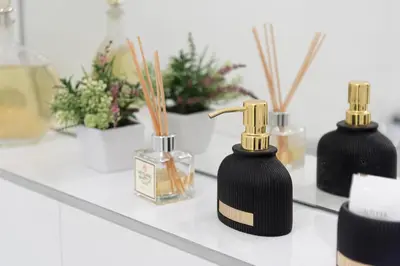 two black and gold bottles on a shelf with flowers at VilniausPanorama in Vilnius