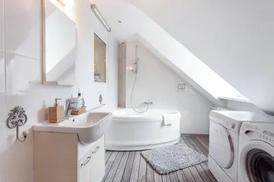 a bathroom with a sink and a washing machine at Castle View Apartment by Reside Baltic in Vilnius