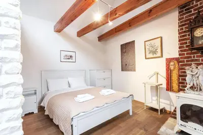 a bedroom with a white bed and a fireplace at Castle View Apartment by Reside Baltic in Vilnius