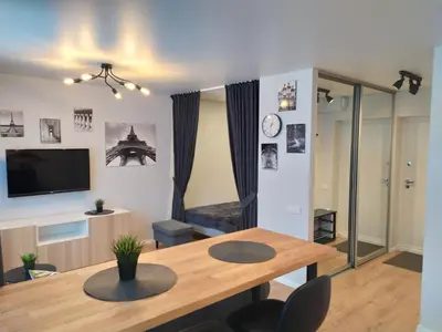a living room with a wooden table and a television at Studija Alytuje in Alytus