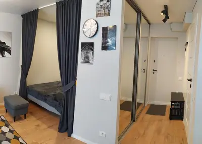 a room with a mirror and a clock on a wall at Studija Alytuje in Alytus
