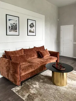 a living room with a brown couch and a table at Kamurke - Apartamentai in Šiauliai