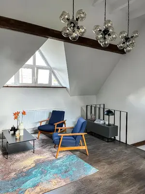 a living room with blue chairs and a table at Kamurke - Apartamentai in Šiauliai