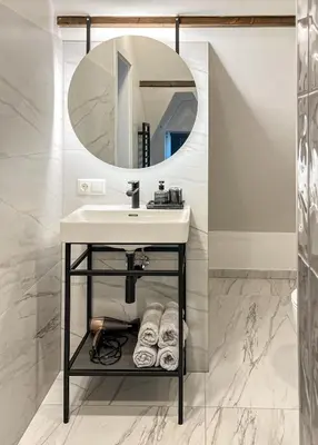 a bathroom with a sink and a mirror at Kamurke - Apartamentai in Šiauliai