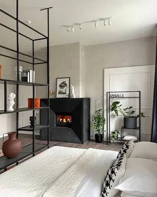 a bedroom with a bed and a fireplace at Kamurke - Apartamentai in Šiauliai