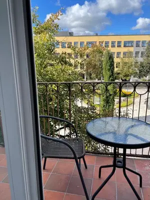 a balcony with a table and chairs and a building at Lindens apartments with AC and view to central square in Panevėžys