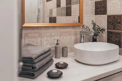 a bathroom with a sink and towels on a counter at Lindens apartments with AC and view to central square in Panevėžys