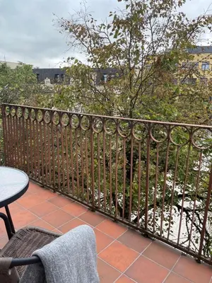 a balcony with a wrought iron fence and a table at Lindens apartments with AC and view to central square in Panevėžys
