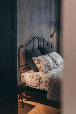 a bedroom with a bed with a metal frame at Lindens apartments with AC and view to central square in Panevėžys