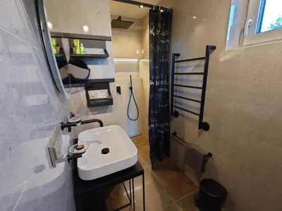 a bathroom with a white sink and a shower at MĖTA in Birštonas