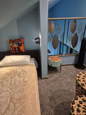 a bedroom with a bed and a table in a room at MĖTA in Birštonas