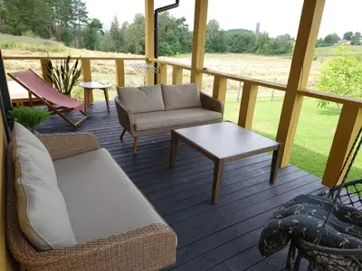 a porch with a couch and a coffee table at MĖTA in Birštonas