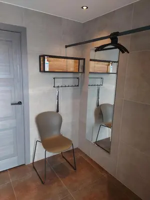 a room with a chair and a mirror and a door at MĖTA in Birštonas