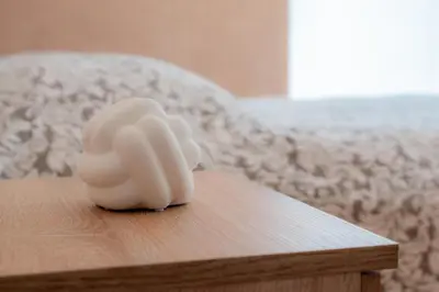 a white sculpture on a wooden table with a couch at Jaukus svečių namelis in Druskininkai
