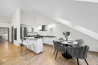 a kitchen and dining room with a table and chairs at Kaunas Old Town apartment with underground parking in Kaunas